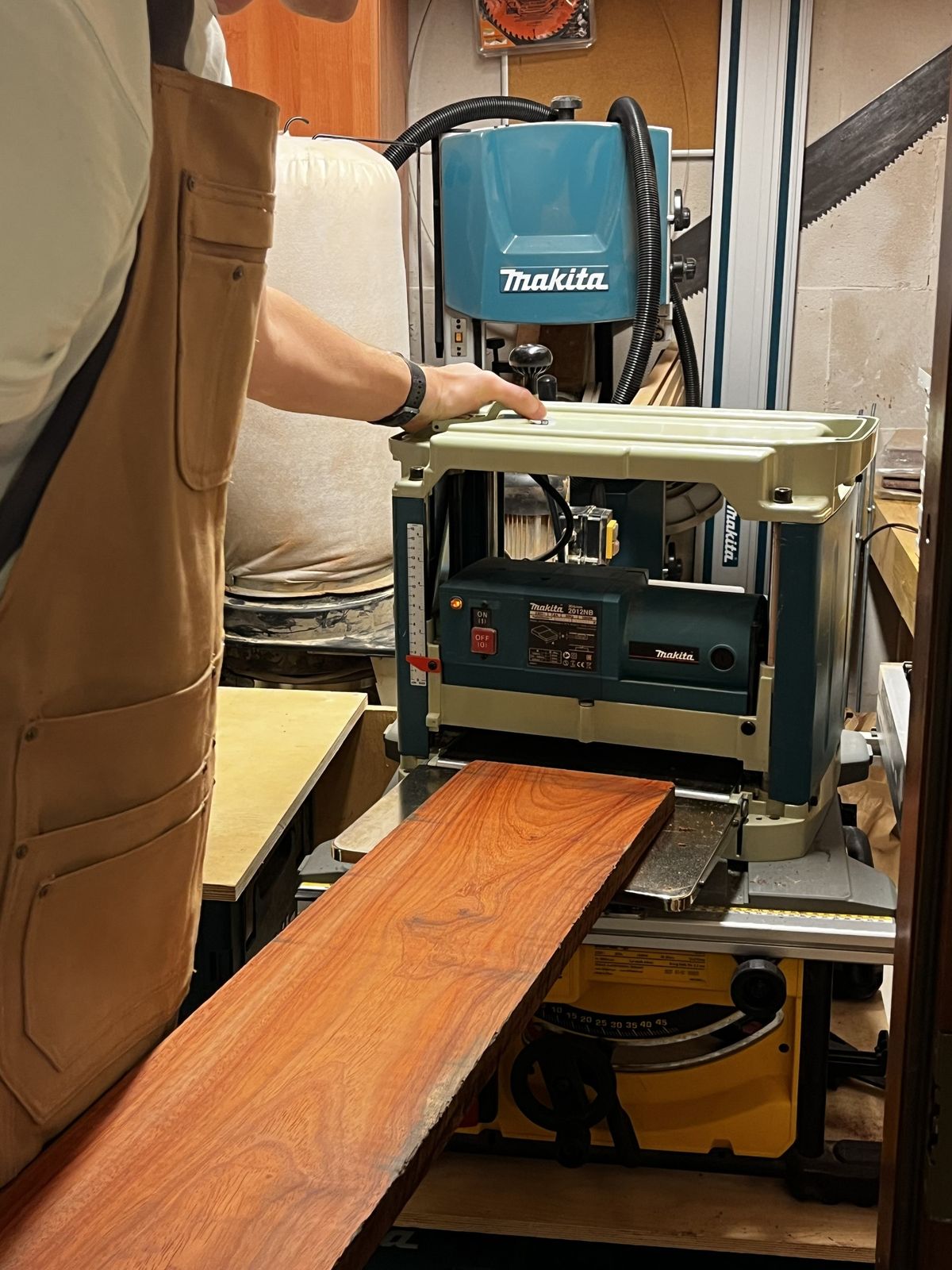 Craftsman finishing padouk wood with a thickness planer